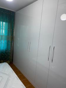 a white cabinet in a bedroom with a bed at Amber Comfort Home in Lushnjë