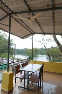 a table and chairs with a view of a river at kali river view in Dandeli +14 photos