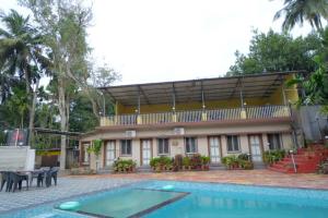 a house with a swimming pool in front of it at kali river view in Dandeli