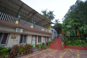 a building with a red door and some plants at kali river view in Dandeli