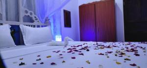 Una cama con flores y un cisne encima. en SeaRenityHomesWatamu, en Watamu