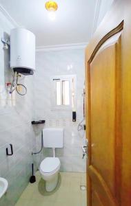 a bathroom with a toilet and a sink at Mike's HOUSE in Yaoundé +6 photos