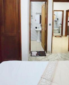 a room with a bathroom with a toilet and a mirror at Mike's HOUSE in Yaoundé