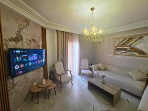 a living room with a couch and a tv at Zen home Lac 2 in La Marsa