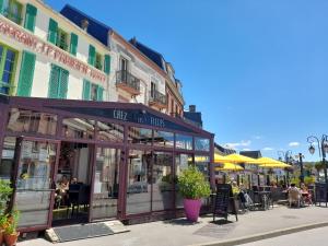 un bâtiment avec un café et des tables dans une rue dans l'établissement L'ALBIZIA à 20m de la plage 3ème etage, rénové, 2 personnes et animaux - wifi, à Mers-les-Bains