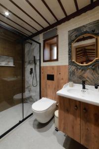 a bathroom with a toilet and a sink and a shower at Scandinavian Rustic in Tríkala +24 photos
