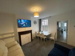 a living room with a couch and a table and a tv at Livingwell Home in Gravesend