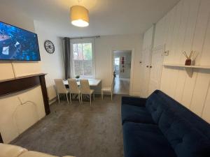 a living room with a blue couch and a table at Livingwell Home in Gravesend