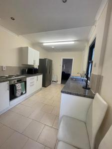 a large kitchen with white cabinets and a counter at Livingwell Home in Gravesend +41 photos