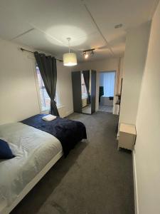 a bedroom with a bed and a large window at Livingwell Home in Gravesend