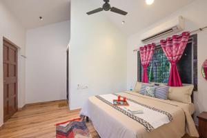 een slaapkamer met een bed en een plafondventilator bij ll EMPYREAN STAY ll REVDANDA BEACH ll in Revadanda