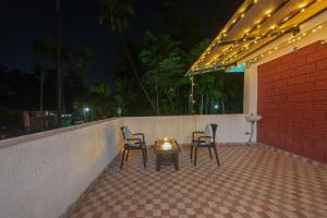 2 stoelen en een tafel op een patio 's nachts bij ll EMPYREAN STAY ll REVDANDA BEACH ll in Revadanda