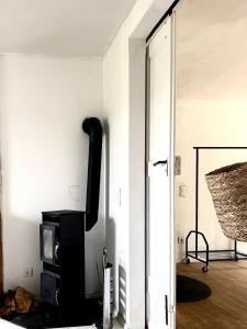 a living room with a tv and a door open at Uriges Apartment 60qm in einem alten Häuschen am Waldrand - 10km bis Würzburg in Reichenberg