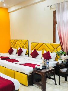 a hotel room with two beds and a table at Vaidik Vedaas Villa Ayodhya- Ram Paidi in Ayodhya