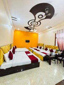 two beds in a room with yellow and red at Vaidik Harmony Ayodhya in Ayodhya
