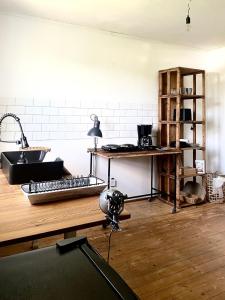 a kitchen with a sink and a desk with a keyboard at Uriges Apartment 60qm in einem alten Häuschen am Waldrand - 10km bis Würzburg in Reichenberg