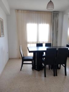 a dining room with a table and chairs and a window at Dar selma in Port El Kantaoui