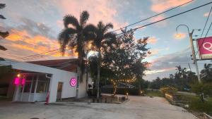 una palmera frente a un edificio con puesta de sol en P2 by Passion : พีทู รีสอร์ต วังรัก, en Nakhon Si Thammarat 17 fotos más