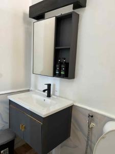 een badkamer met een wastafel en een spiegel bij Mia's Place in El Nido