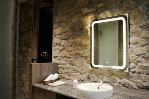 een badkamer met een wastafel en een spiegel aan een stenen muur bij Elan Luxuria Jawai in Bijāpur +7 foto's