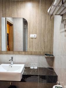 a bathroom with a sink and a mirror at Front One Luxe Hotel Solo in Solo