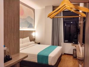 a hotel room with a bed and a window at Front One Luxe Hotel Solo in Solo