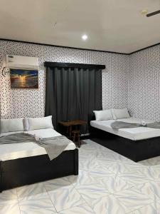 een slaapkamer met twee bedden en een tafel erin bij Mia's Place in El Nido