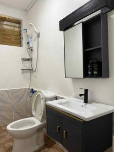 een badkamer met een wit toilet en een wastafel bij Mia's Place in El Nido +12 foto's