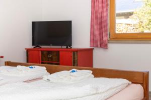 una habitación con dos camas, televisión y toallas. en Goldiger Hirsch B&B mit Kochmöglichkeiten, en Immenstadt im Allgäu