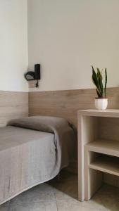 a bedroom with a bed and a table with a potted plant at Hotel Eva in Rimini