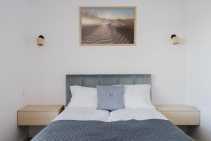 Un dormitorio con una cama y un cuadro en la pared. en S1 Apartamenty, en Rewa