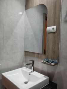 a bathroom with a white sink and a mirror at Front One Luxe Hotel Solo in Solo
