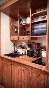 une cuisine avec des armoires en bois et un comptoir dans l'établissement Muzyczny Dworek, à Rzepiska