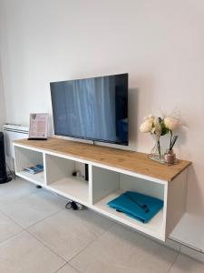 a tv on top of a white entertainment center at L'Espadon - vue mer, proche plage et gare in Menton