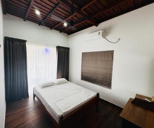 a bedroom with a bed and a window at Vembanad Ripples in Alleppey