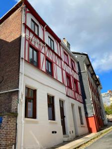 un edificio rojo y blanco al lado de una calle en Studio Cosy & bohème - Quartier Cauchoise, en Rouen