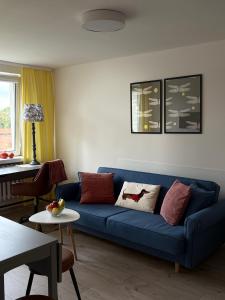 马尔堡Widok na Zamek的客厅里有一张蓝色的沙发和一张桌子