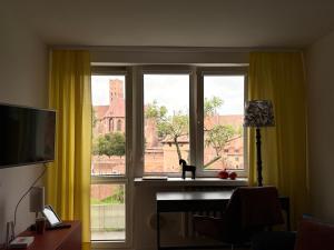 a room with a window with a cat sitting on a desk at Widok na Zamek in Malbork