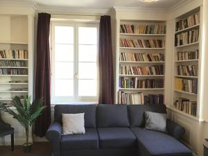 a living room with a blue couch in front of bookshelves at Apartment Castle Square z widokiem na Plac Zamkowy i Zamek Królewski in Warsaw