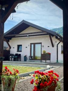 a white house with flowers in front of it at Domki z Widokiem in Wünschelburg