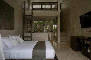a bedroom with a large bed and a television at Tibah in Tanah Lot