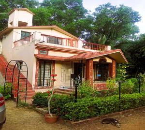 サンティ・ニケタンにあるARANYAK Homestayのポーチとバルコニー付きの家