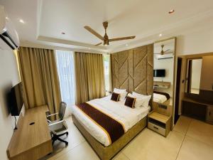 a hotel room with a bed and a desk and a television at Munnar Peak Paradise in Anachal