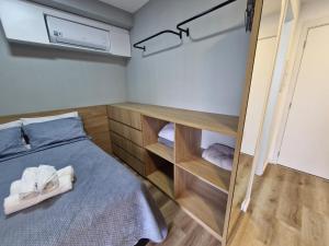 a bedroom with a bed with towels on it at Studio Prático no Brooklin Próx ao Metro in São Paulo