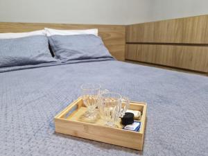 a wooden tray with glasses on a bed at Studio Prático no Brooklin Próx ao Metro in São Paulo