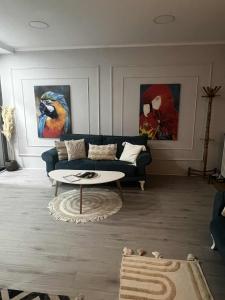 a living room with a couch and two paintings at JUCIN apartman in Zrenjanin