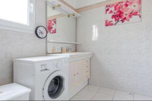 eine Waschküche mit Waschmaschine und Waschbecken in der Unterkunft logement indépendant avec jardinet in Bouc-Bel-Air + 1 Foto