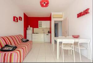 ein Wohnzimmer mit Couch und Tisch und eine Küche in der Unterkunft logement indépendant avec jardinet in Bouc-Bel-Air