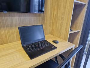 a laptop computer sitting on a desk with a mouse at Studio Prático no Brooklin Próx ao Metro in São Paulo