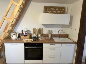 a kitchen with white cabinets and a sink at Le domaine des amours in Saint-Josse